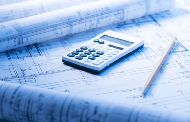 financing architectural project, blueprints rolls, calculator, pencil